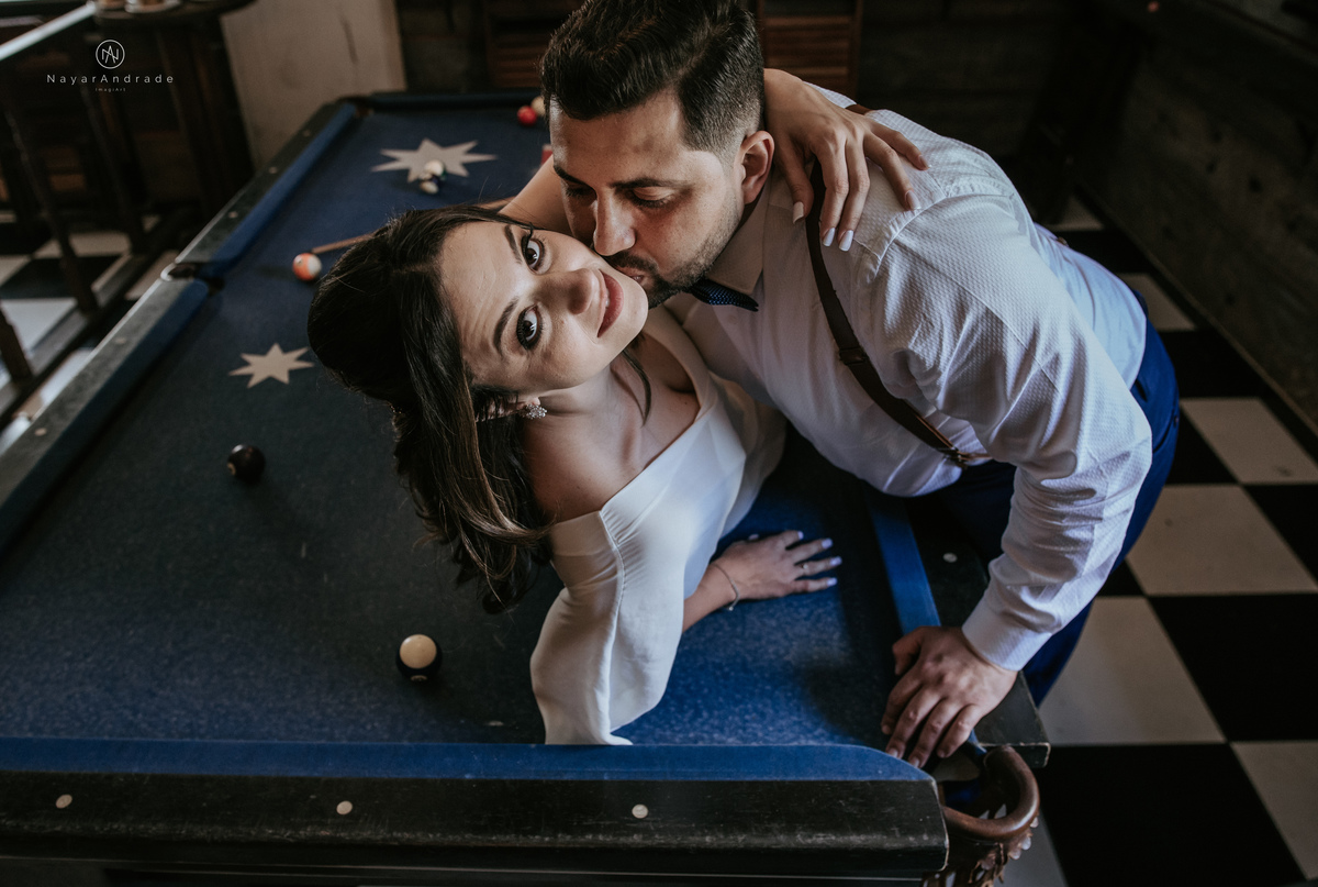 Mini wedding em Santos no australiano bar, noiva com vestido longo de fenda e noivo de suspensorio e gravata borboleta. Fotos de casamento na mesa de sinucae no bar. Casal apaixonado em mini wedd de manha