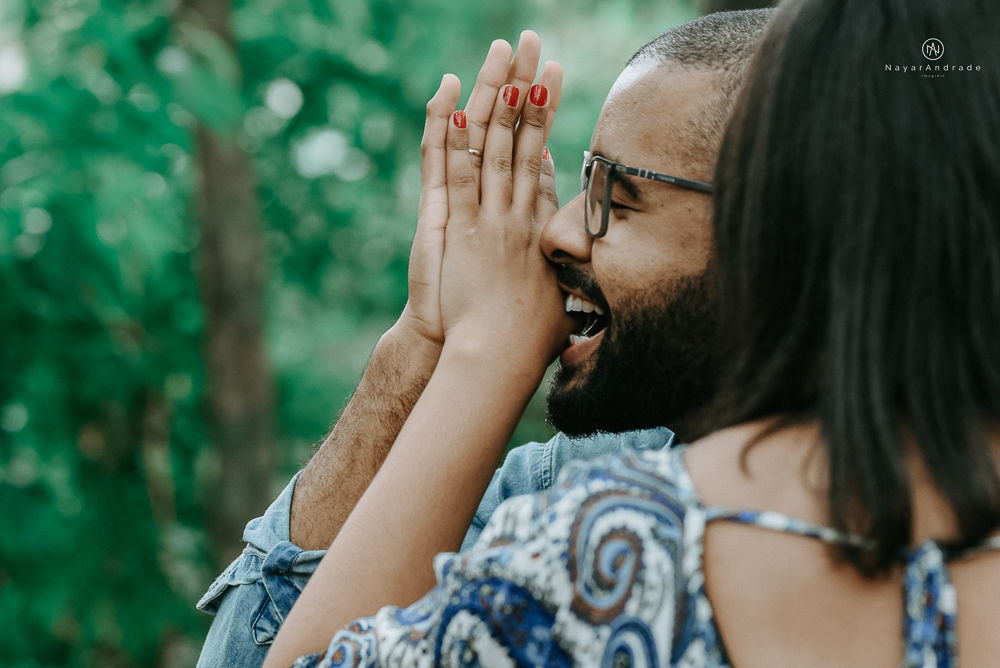 Ensaio de dia no parque com casal de roupa jeans em um clima romantico