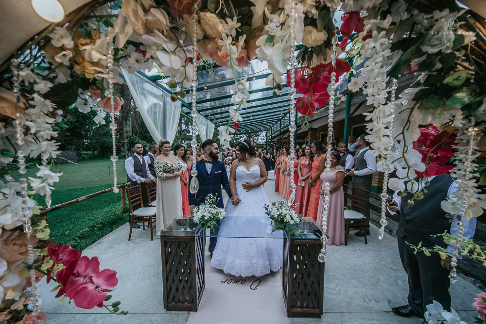 casamento ao ar livre de dia com noiva princesa e noivo de terno azul e gravata borboleta de madeira decoracao com guirlanda e padrinhos com balao de coracao