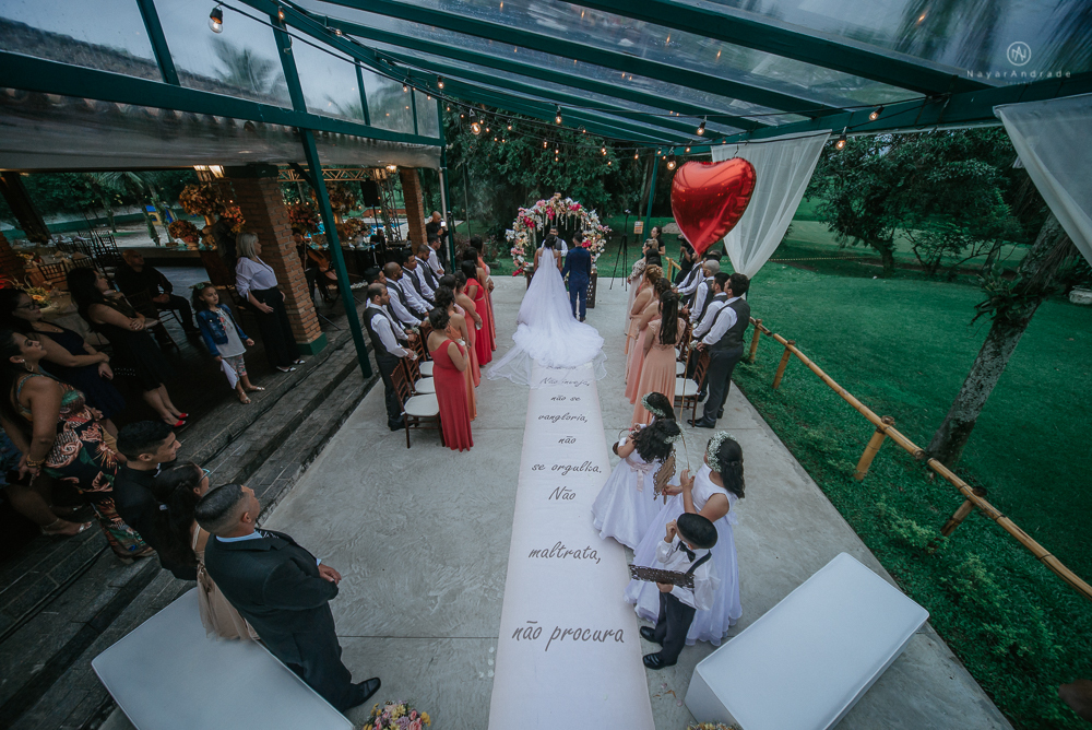 casamento ao ar livre de dia com noiva princesa e noivo de terno azul e gravata borboleta de madeira decoracao com guirlanda e padrinhos com balao de coracao