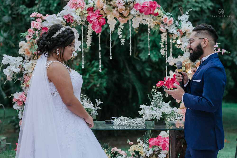 casamento ao ar livre de dia com noiva princesa e noivo de terno azul e gravata borboleta de madeira decoracao com guirlanda e padrinhos com balao de coracao