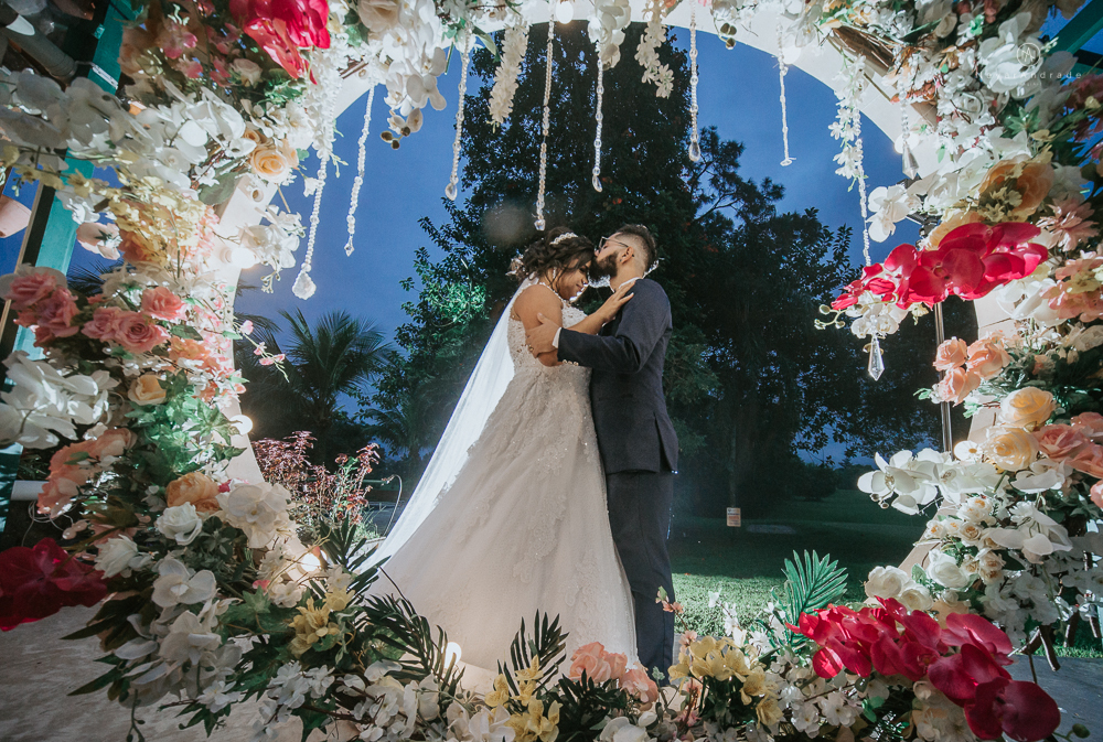 casamento ao ar livre de dia com noiva princesa e noivo de terno azul e gravata borboleta de madeira decoracao com guirlanda e padrinhos com balao de coracao