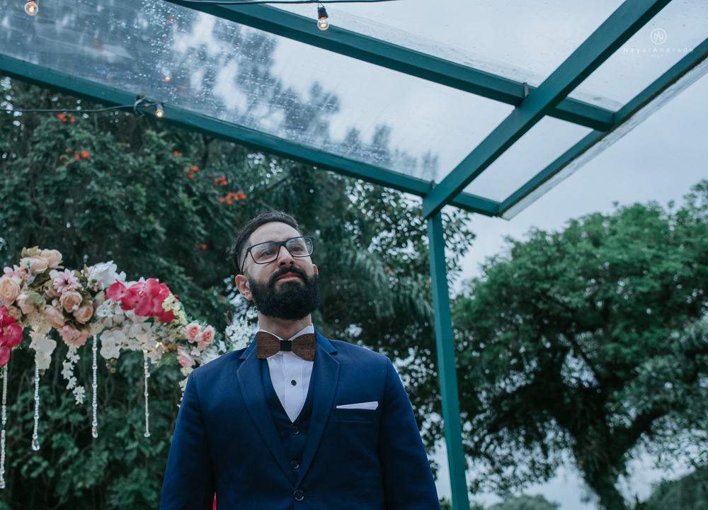 casamento ao ar livre de dia com noiva princesa e noivo de terno azul e gravata borboleta de madeira decoracao com guirlanda e padrinhos com balao de coracao