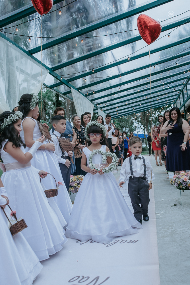 casamento ao ar livre de dia com noiva princesa e noivo de terno azul e gravata borboleta de madeira decoracao com guirlanda e padrinhos com balao de coracao