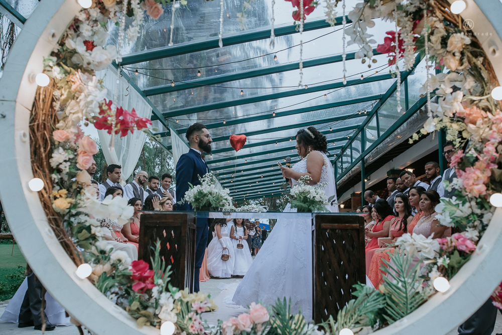 casamento ao ar livre de dia com noiva princesa e noivo de terno azul e gravata borboleta de madeira decoracao com guirlanda e padrinhos com balao de coracao
