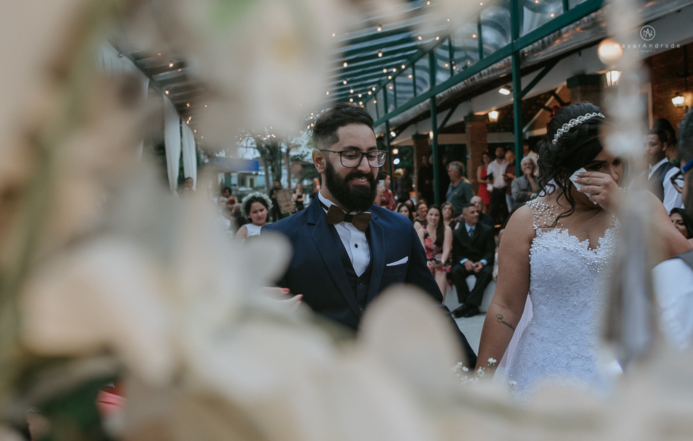 casamento ao ar livre de dia com noiva princesa e noivo de terno azul e gravata borboleta de madeira decoracao com guirlanda e padrinhos com balao de coracao