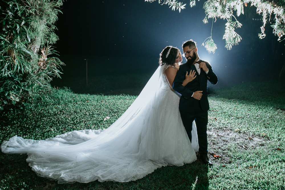 casamento ao ar livre de dia com noiva princesa e noivo de terno azul e gravata borboleta de madeira decoracao com guirlanda e padrinhos com balao de coracao