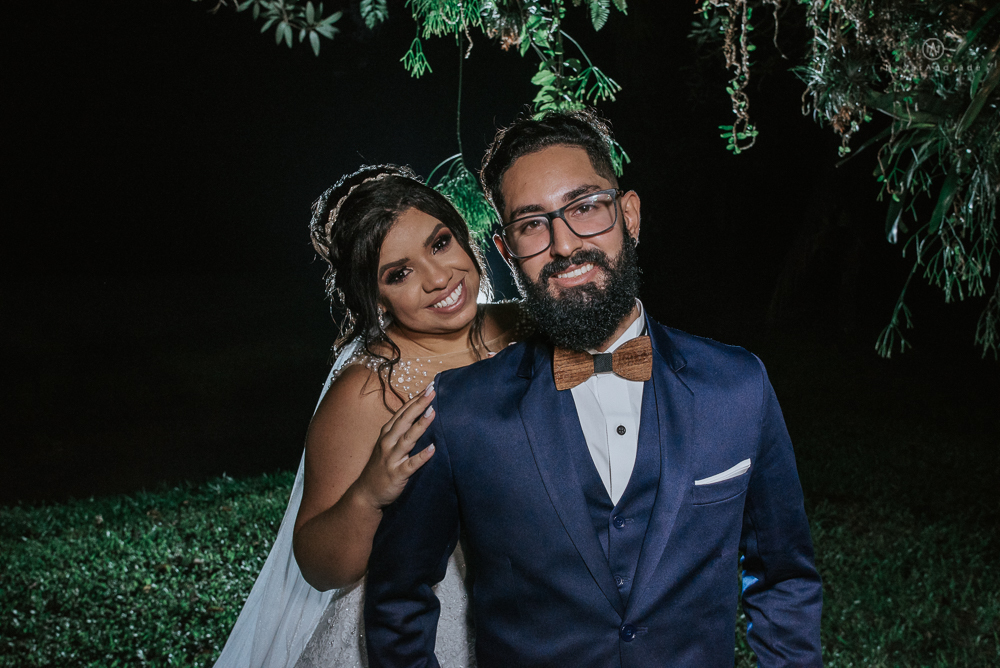 casamento ao ar livre de dia com noiva princesa e noivo de terno azul e gravata borboleta de madeira decoracao com guirlanda e padrinhos com balao de coracao