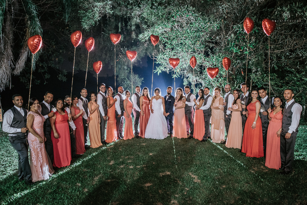 casamento ao ar livre de dia com noiva princesa e noivo de terno azul e gravata borboleta de madeira decoracao com guirlanda e padrinhos com balao de coracao