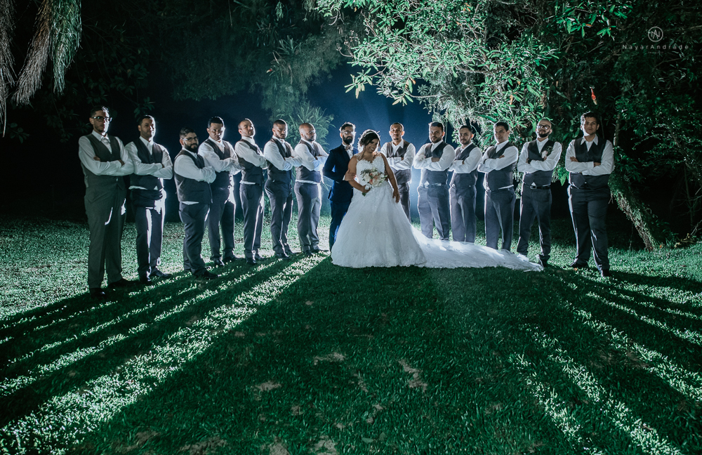 casamento ao ar livre de dia com noiva princesa e noivo de terno azul e gravata borboleta de madeira decoracao com guirlanda e padrinhos com balao de coracao