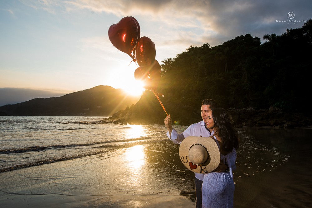 ensaio casal com por do sol balao data e foto incrivel na praia das conchas iporanga no guaruja com a fotografa nayara andrade noiva de vestido longo branco