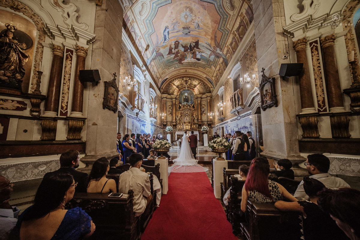 casamento classico noivo com terno marsala e noiva com mantilha no santuario de santo antonio do valongo em santos fotos feitas com o por do sol pela fotografa premiada nayara andrade de santos