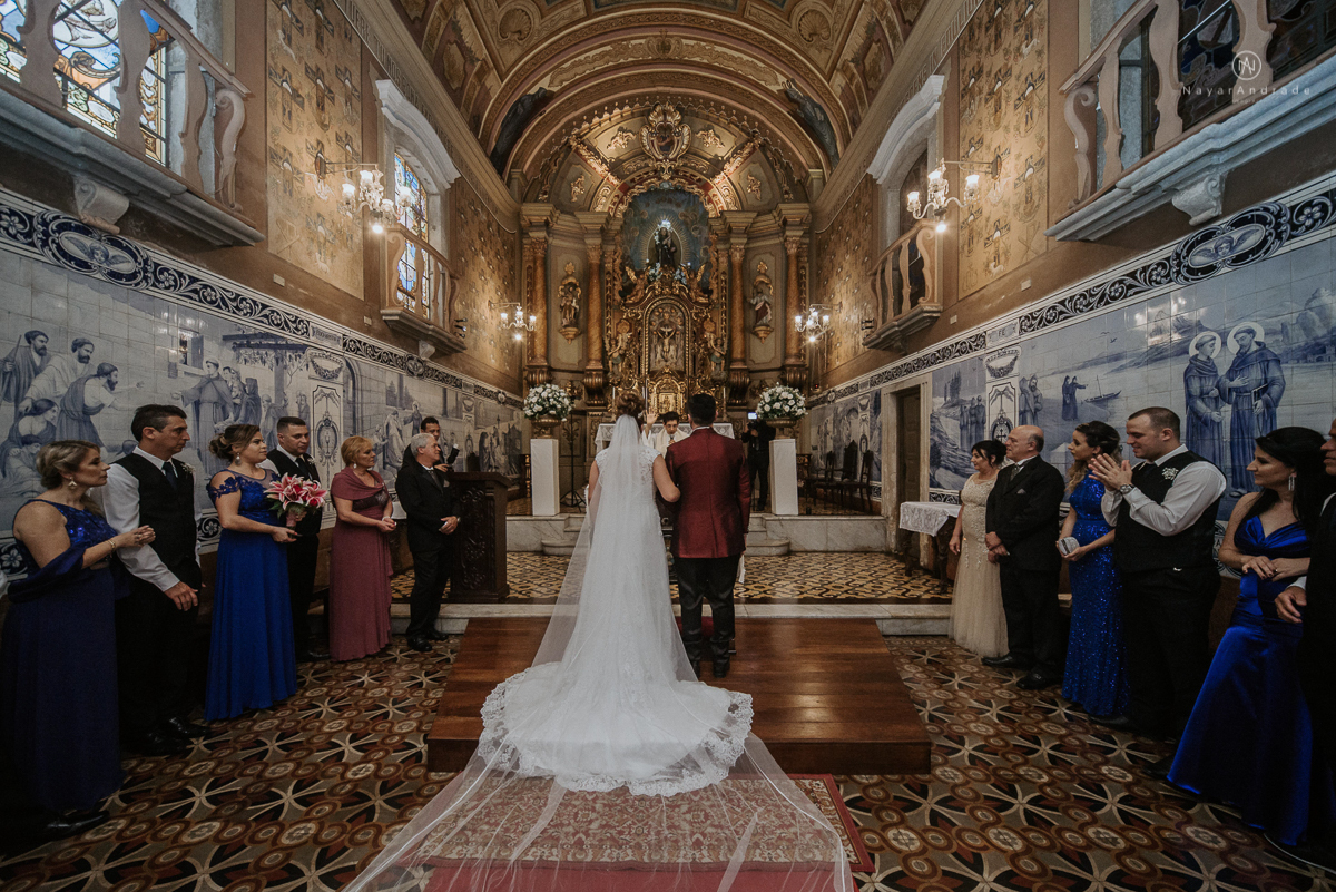 casamento classico noivo com terno marsala e noiva com mantilha no santuario de santo antonio do valongo em santos fotos feitas com o por do sol pela fotografa premiada nayara andrade de santos
