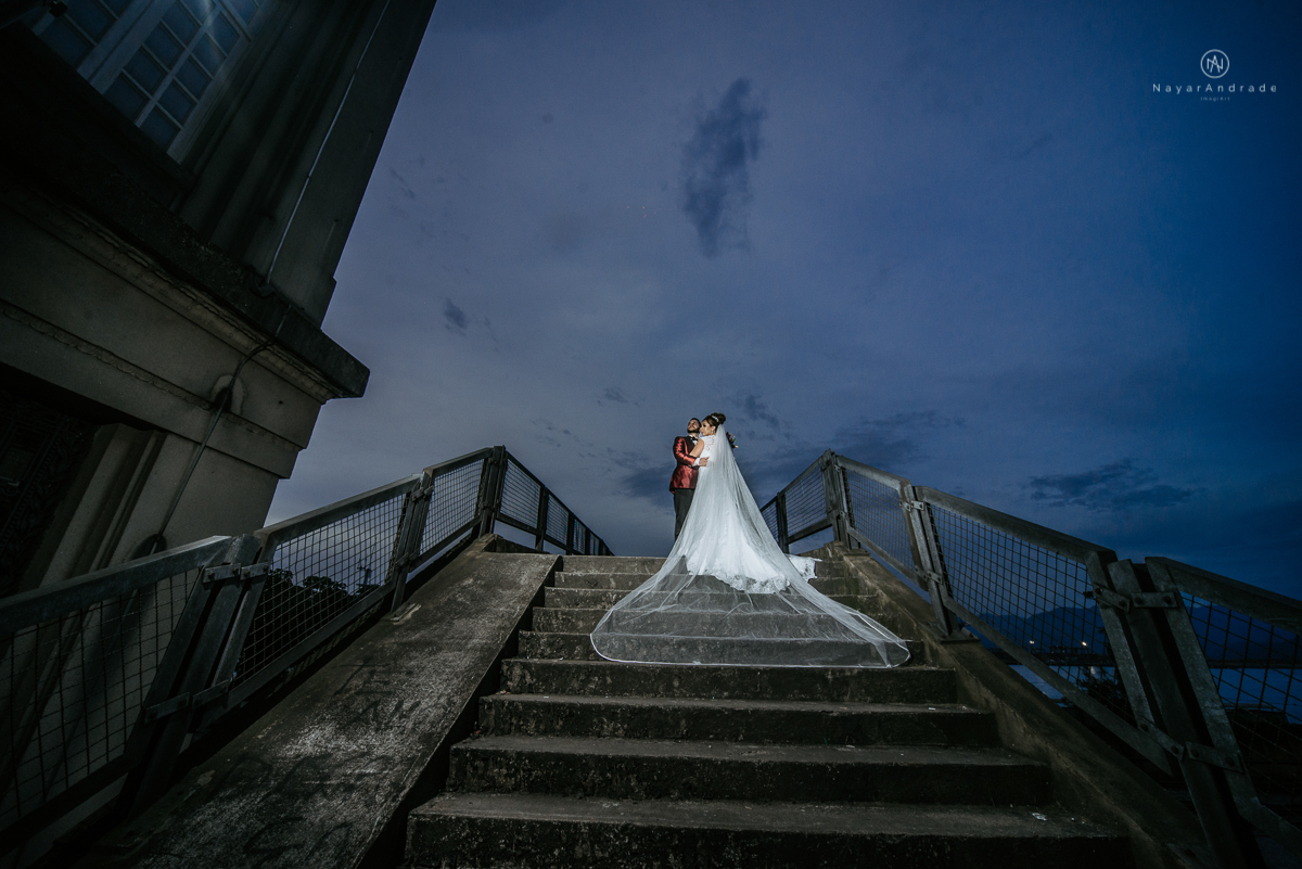 casamento classico noivo com terno marsala e noiva com mantilha no santuario de santo antonio do valongo em santos fotos feitas com o por do sol pela fotografa premiada nayara andrade de santos