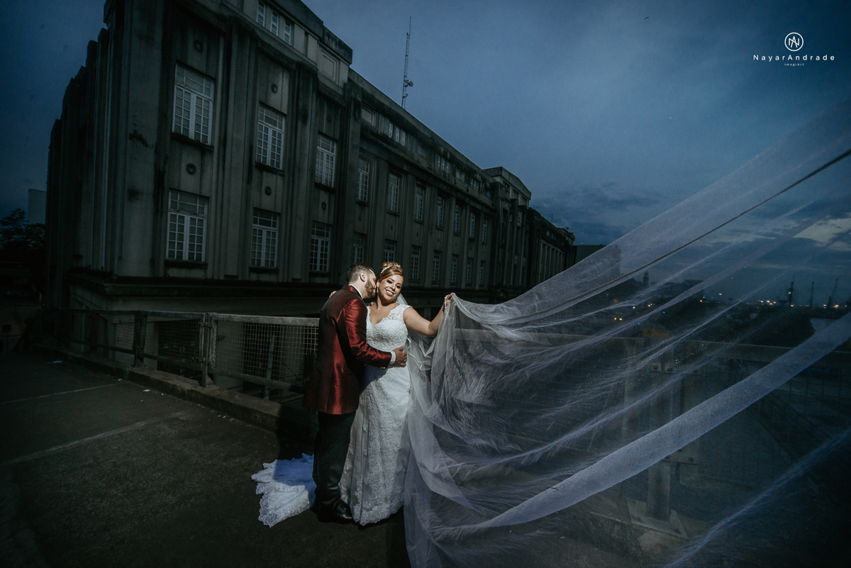 casamento classico noivo com terno marsala e noiva com mantilha no santuario de santo antonio do valongo em santos fotos feitas com o por do sol pela fotografa premiada nayara andrade de santos