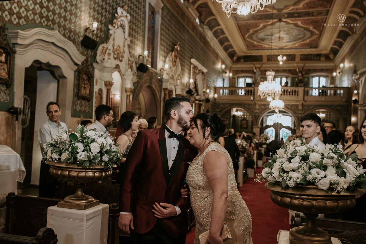 casamento classico noivo com terno marsala e noiva com mantilha no santuario de santo antonio do valongo em santos fotos feitas com o por do sol pela fotografa premiada nayara andrade de santos