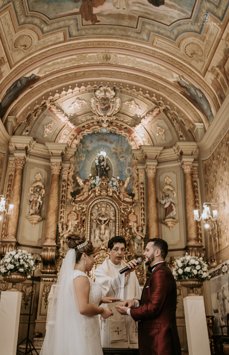 casamento classico noivo com terno marsala e noiva com mantilha no santuario de santo antonio do valongo em santos fotos feitas com o por do sol pela fotografa premiada nayara andrade de santos