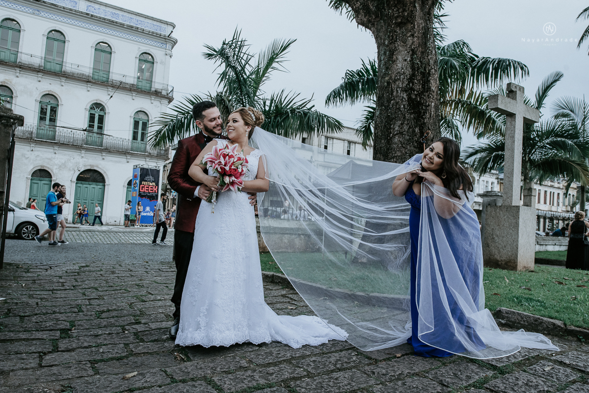 casamento classico noivo com terno marsala e noiva com mantilha no santuario de santo antonio do valongo em santos fotos feitas com o por do sol pela fotografa premiada nayara andrade de santos