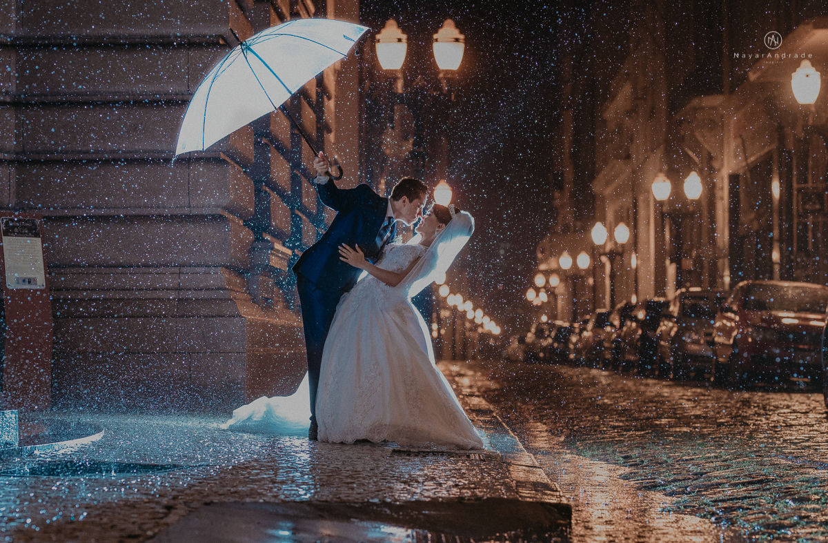 casamento feito em dia de chuva com lindas e apaixonantes fotos na chuva noivo de terno azul e noiva de mantilha