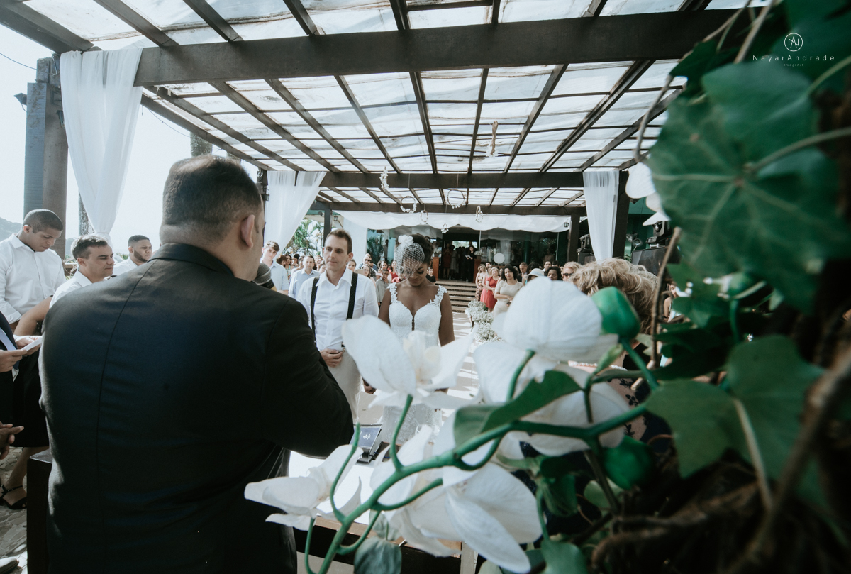 casamento italobrasileiro entre italiano e brasileira em lugar rustico ao ar livre de dia em clima descontraido noivo de all star noivo loiro e noiva negra tema com uvas e italia