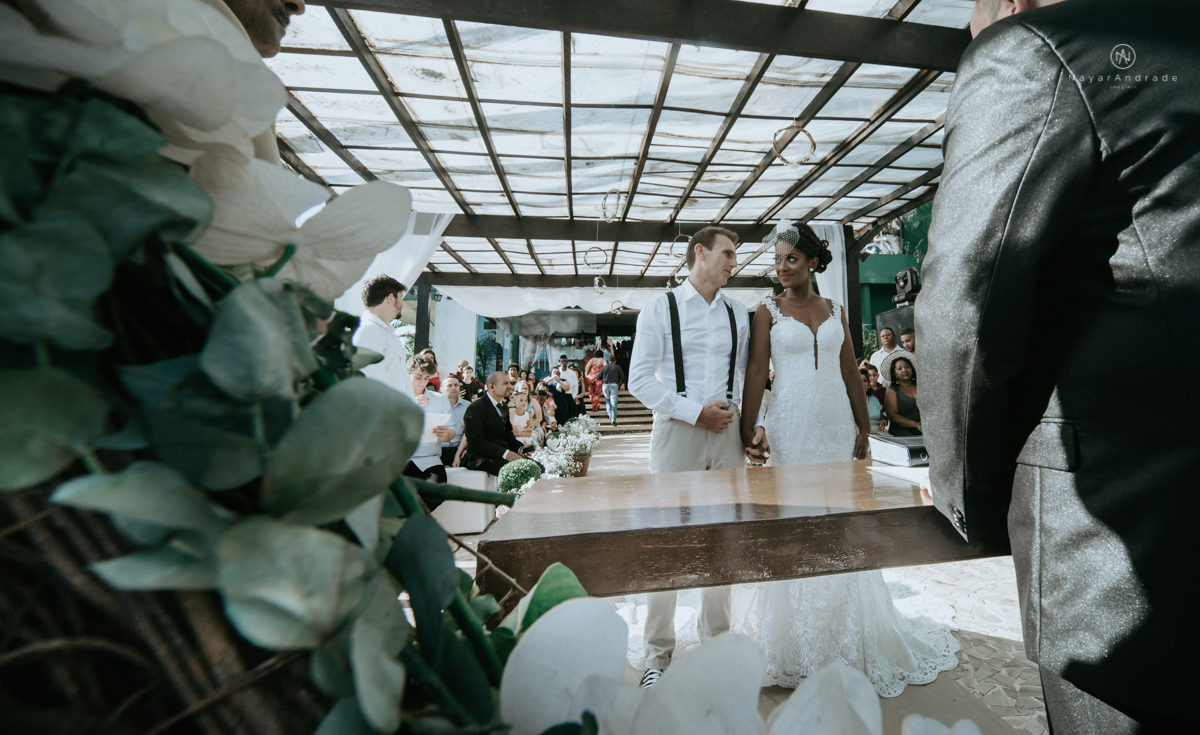 casamento italobrasileiro entre italiano e brasileira em lugar rustico ao ar livre de dia em clima descontraido noivo de all star noivo loiro e noiva negra tema com uvas e italia