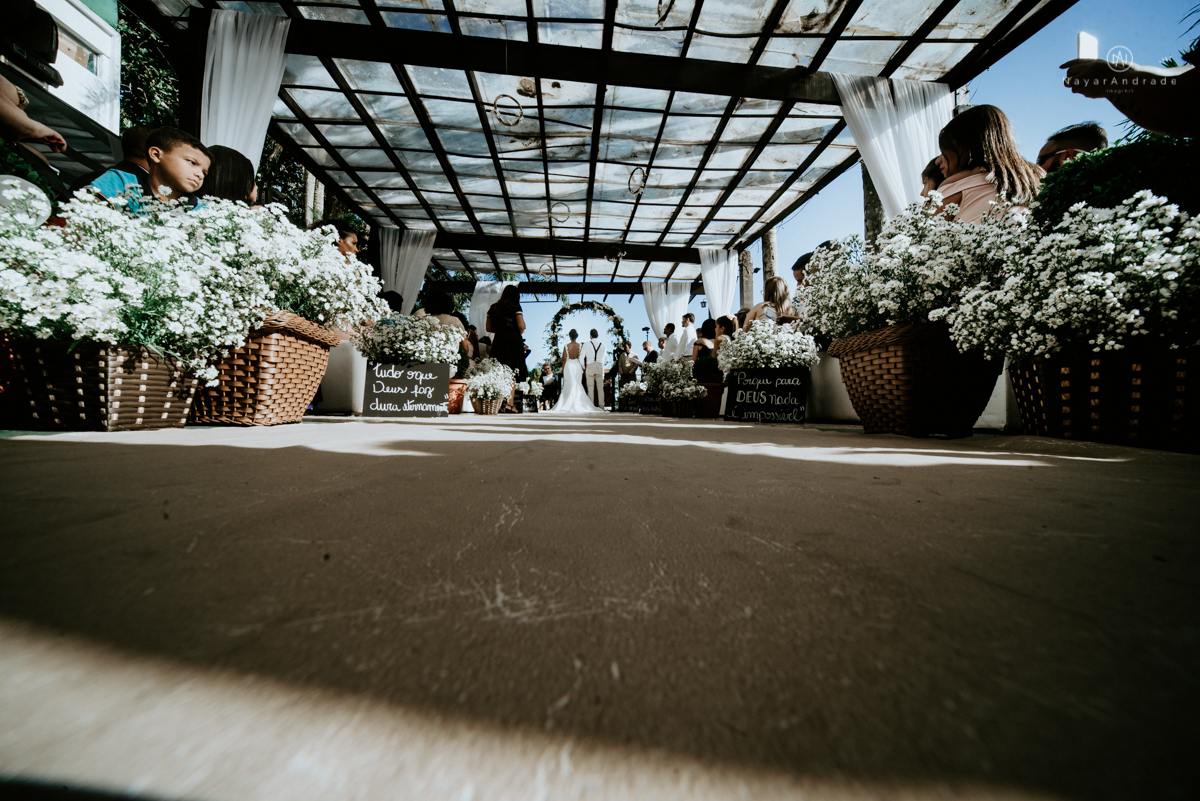 casamento italobrasileiro entre italiano e brasileira em lugar rustico ao ar livre de dia em clima descontraido noivo de all star noivo loiro e noiva negra tema com uvas e italia