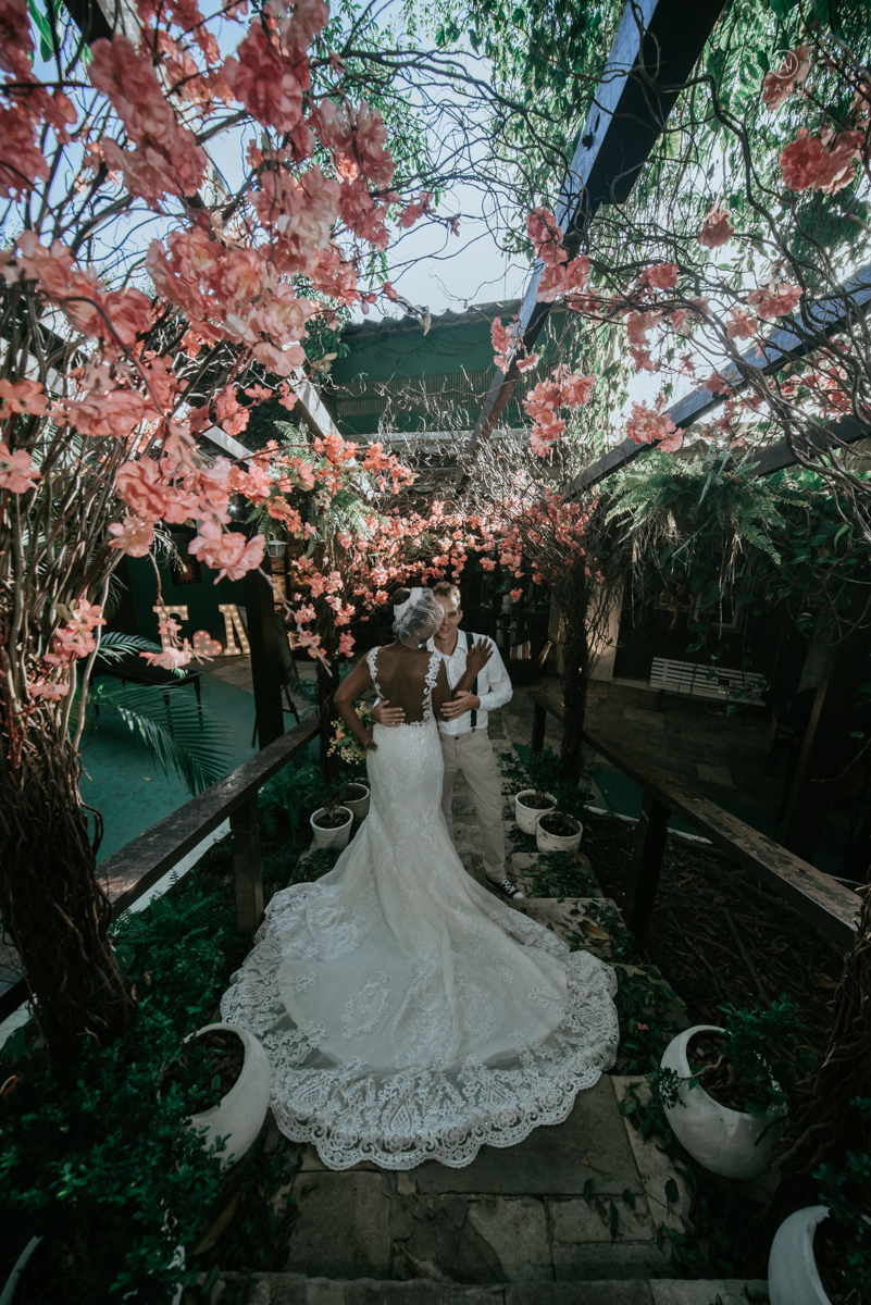 casamento italobrasileiro entre italiano e brasileira em lugar rustico ao ar livre de dia em clima descontraido noivo de all star noivo loiro e noiva negra tema com uvas e italia