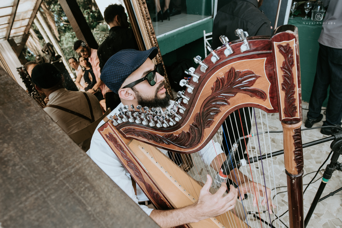 casamento italobrasileiro entre italiano e brasileira em lugar rustico ao ar livre de dia em clima descontraido noivo de all star noivo loiro e noiva negra tema com uvas e italia