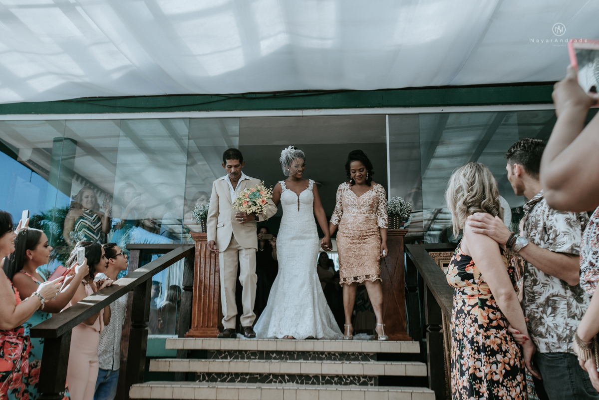 casamento italobrasileiro entre italiano e brasileira em lugar rustico ao ar livre de dia em clima descontraido noivo de all star noivo loiro e noiva negra tema com uvas e italia