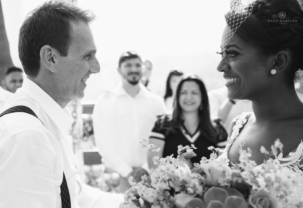 casamento italobrasileiro entre italiano e brasileira em lugar rustico ao ar livre de dia em clima descontraido noivo de all star noivo loiro e noiva negra tema com uvas e italia