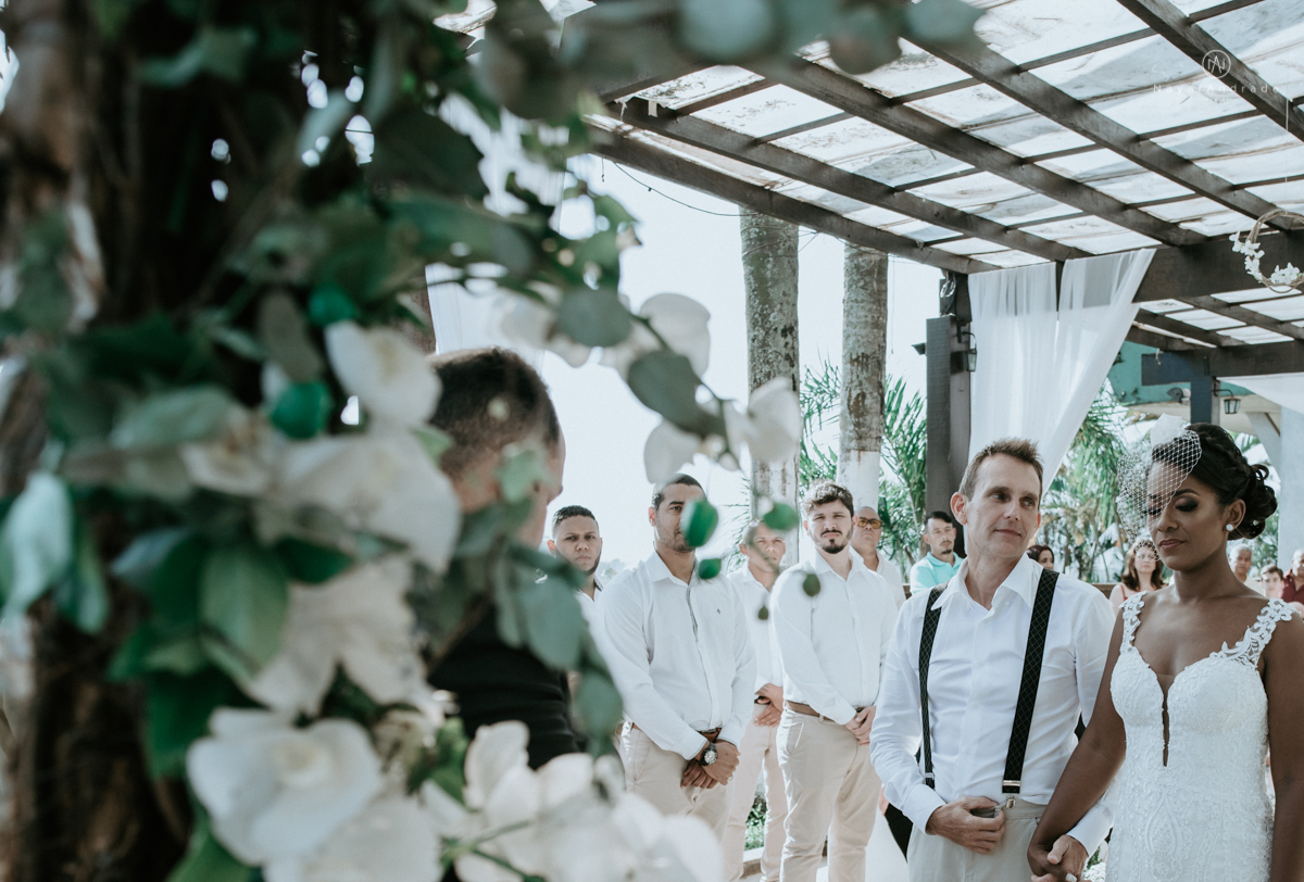 casamento italobrasileiro entre italiano e brasileira em lugar rustico ao ar livre de dia em clima descontraido noivo de all star noivo loiro e noiva negra tema com uvas e italia