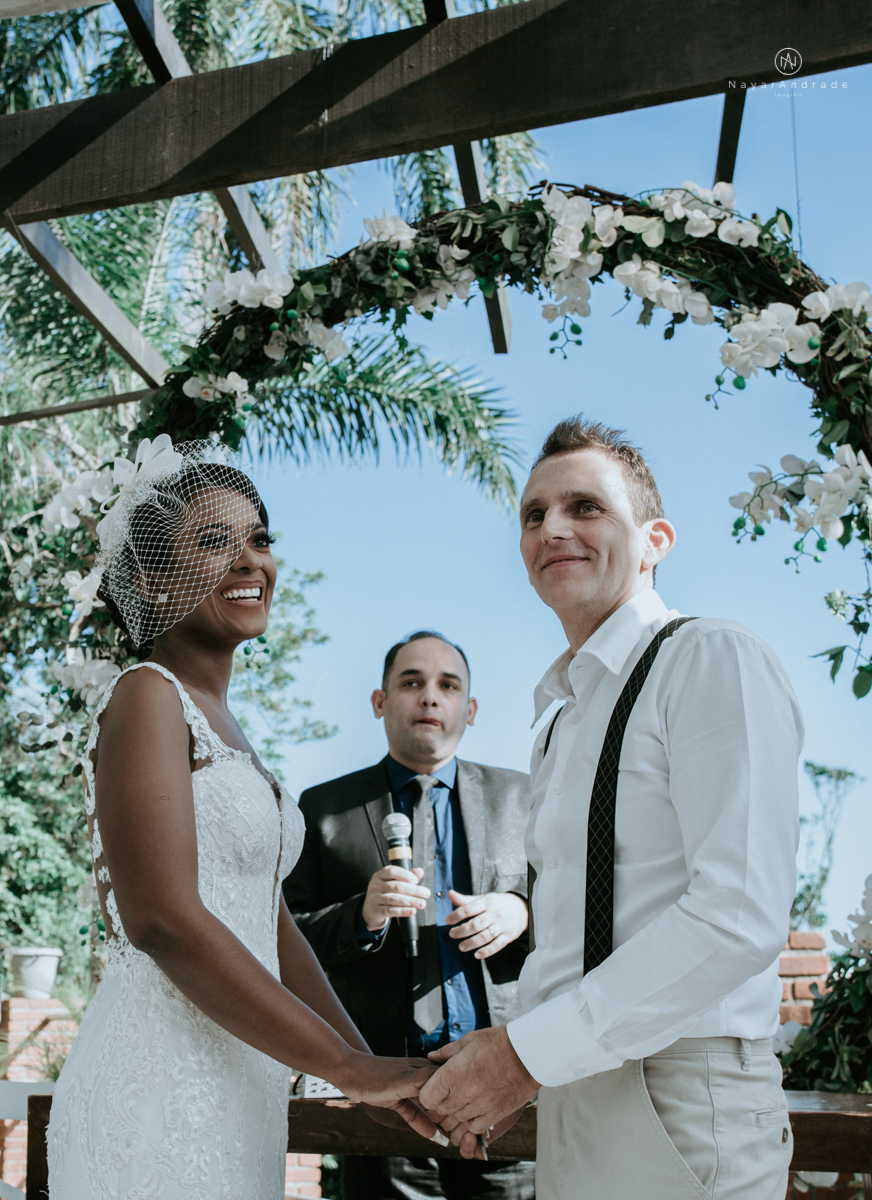 casamento italobrasileiro entre italiano e brasileira em lugar rustico ao ar livre de dia em clima descontraido noivo de all star noivo loiro e noiva negra tema com uvas e italia