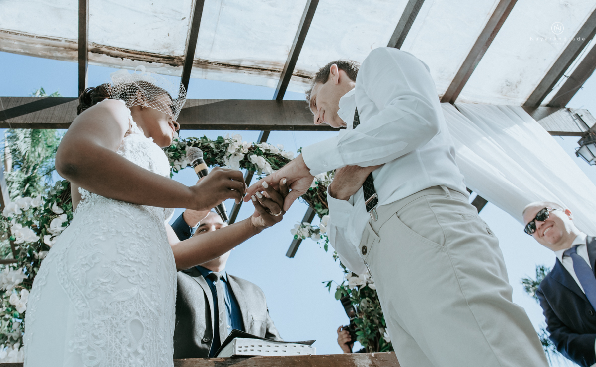 casamento italobrasileiro entre italiano e brasileira em lugar rustico ao ar livre de dia em clima descontraido noivo de all star noivo loiro e noiva negra tema com uvas e italia