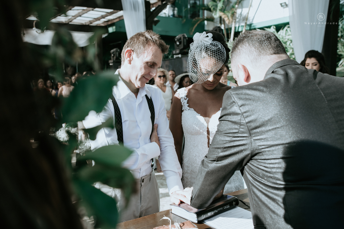 casamento italobrasileiro entre italiano e brasileira em lugar rustico ao ar livre de dia em clima descontraido noivo de all star noivo loiro e noiva negra tema com uvas e italia