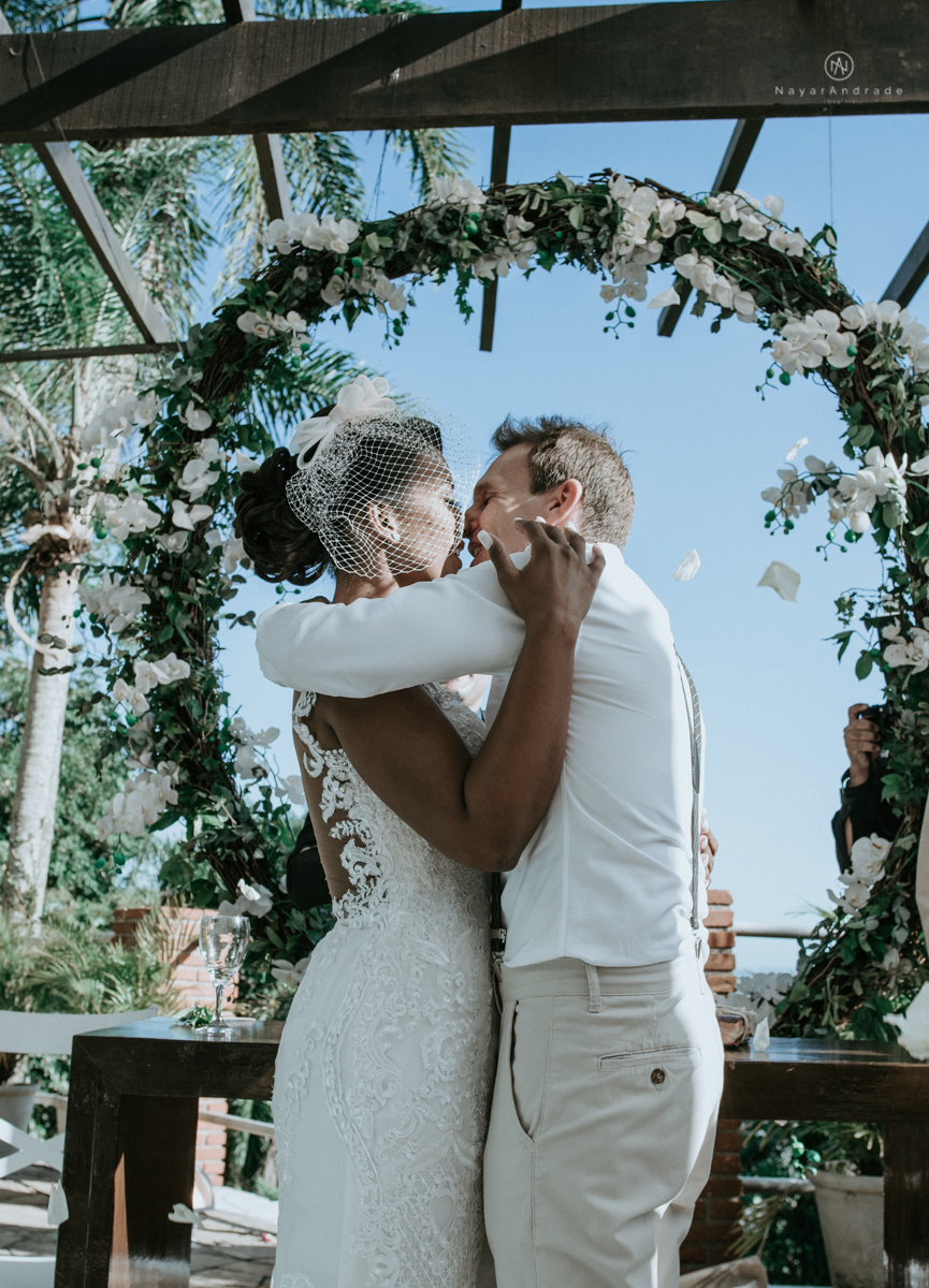 casamento italobrasileiro entre italiano e brasileira em lugar rustico ao ar livre de dia em clima descontraido noivo de all star noivo loiro e noiva negra tema com uvas e italia