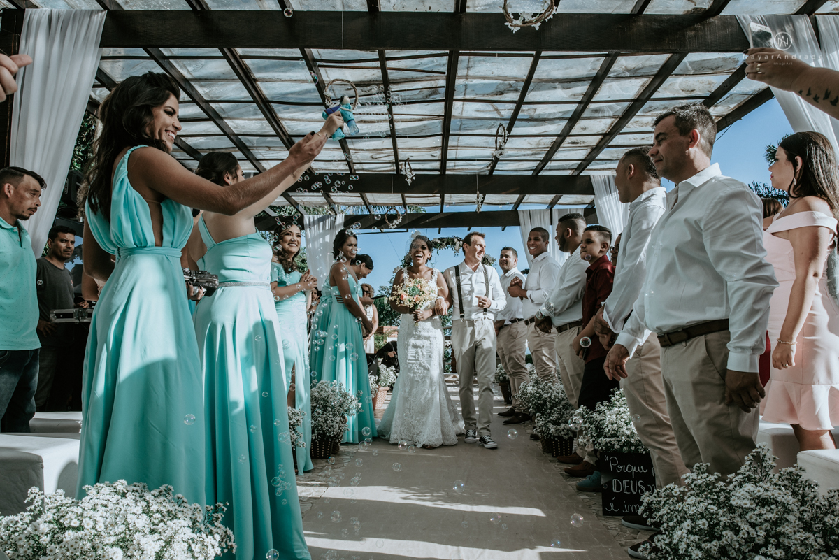 casamento italobrasileiro entre italiano e brasileira em lugar rustico ao ar livre de dia em clima descontraido noivo de all star noivo loiro e noiva negra tema com uvas e italia