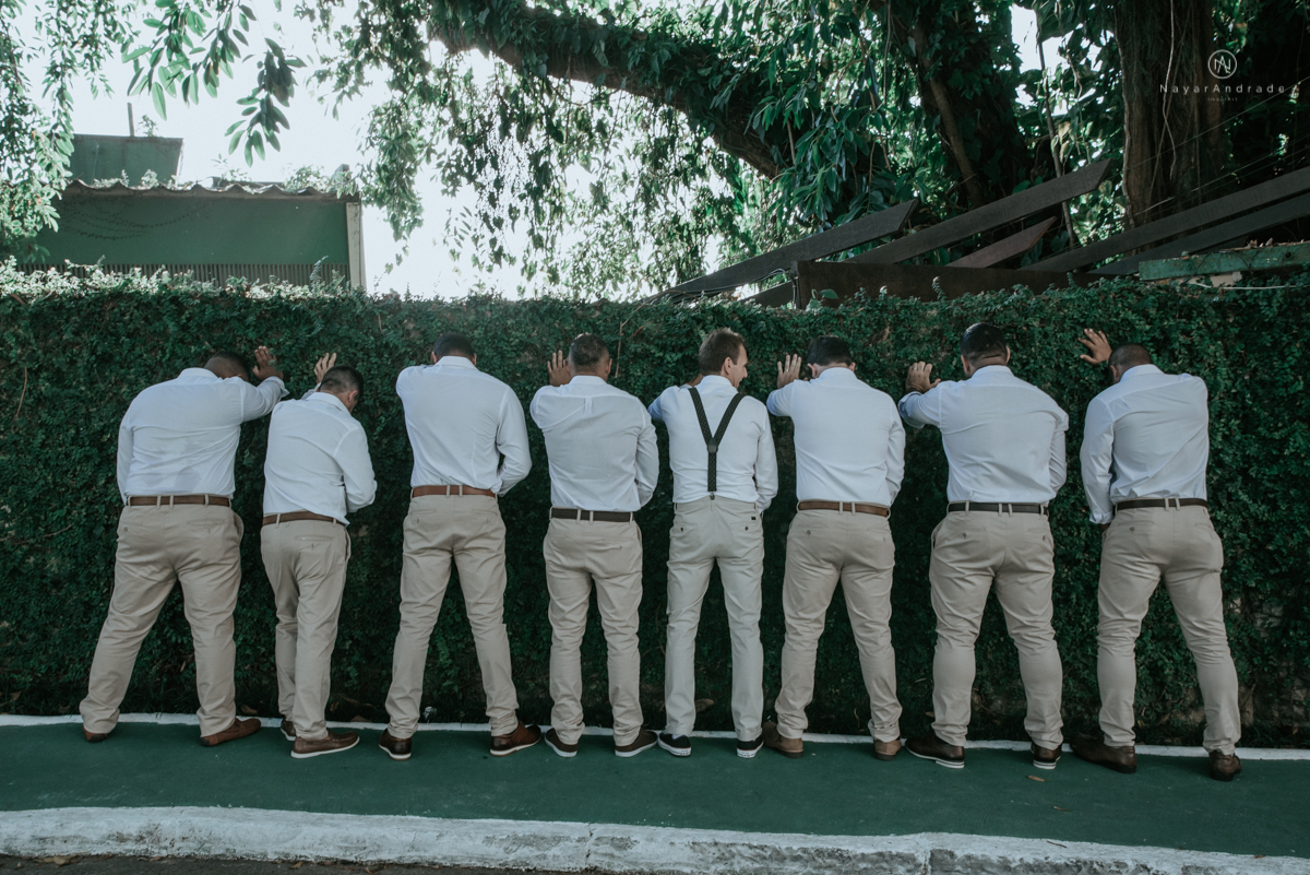 casamento italobrasileiro entre italiano e brasileira em lugar rustico ao ar livre de dia em clima descontraido noivo de all star noivo loiro e noiva negra tema com uvas e italia