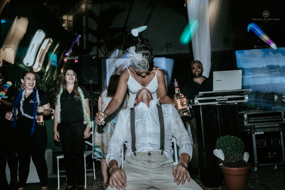 casamento italobrasileiro entre italiano e brasileira em lugar rustico ao ar livre de dia em clima descontraido noivo de all star noivo loiro e noiva negra tema com uvas e italia