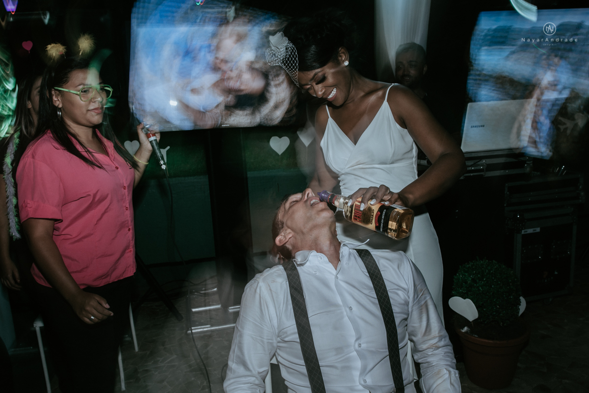 casamento italobrasileiro entre italiano e brasileira em lugar rustico ao ar livre de dia em clima descontraido noivo de all star noivo loiro e noiva negra tema com uvas e italia