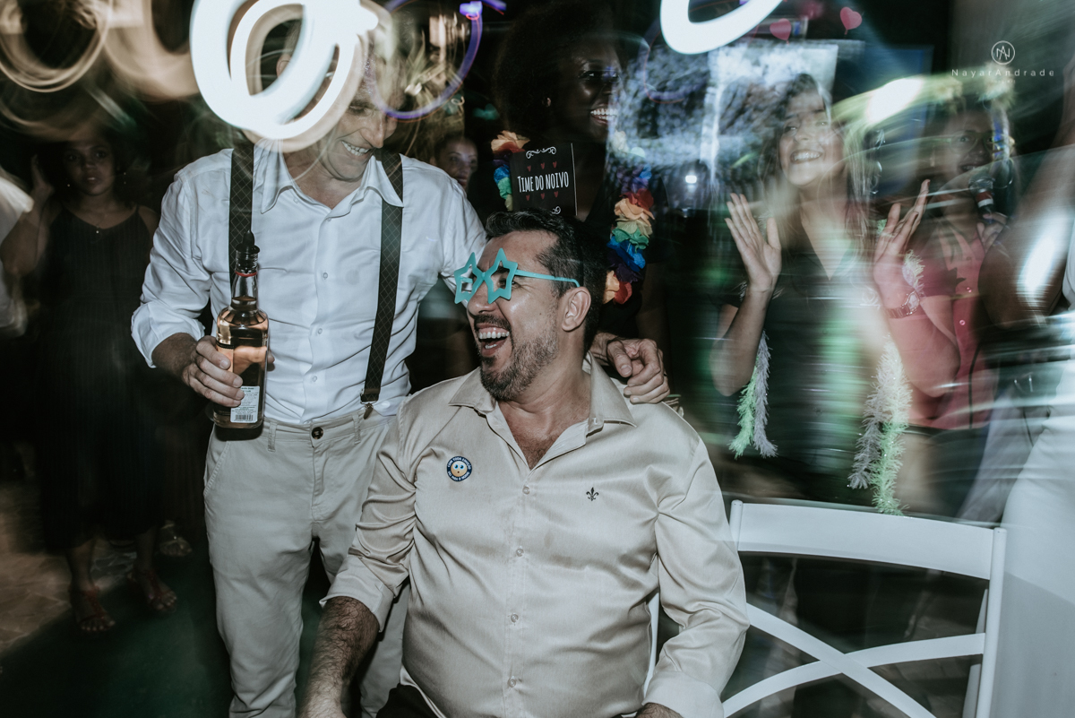 casamento italobrasileiro entre italiano e brasileira em lugar rustico ao ar livre de dia em clima descontraido noivo de all star noivo loiro e noiva negra tema com uvas e italia