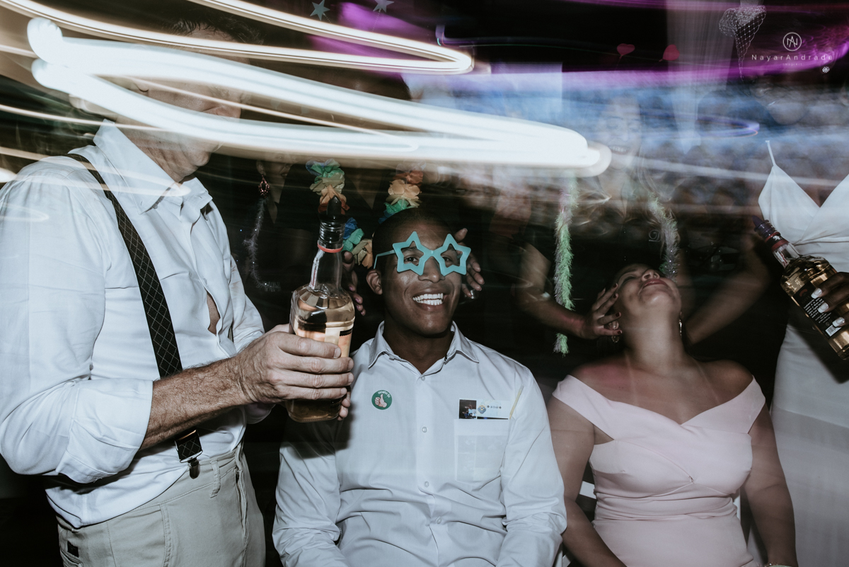 casamento italobrasileiro entre italiano e brasileira em lugar rustico ao ar livre de dia em clima descontraido noivo de all star noivo loiro e noiva negra tema com uvas e italia