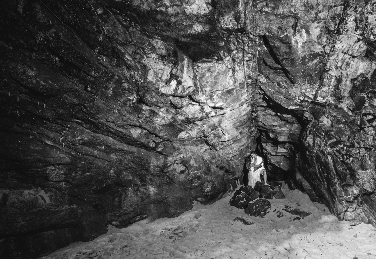 ensaio pre casamento na praia de ubatuba em sao paulo casal de blusa branca com fotos nas pedras e na agua cristalina
