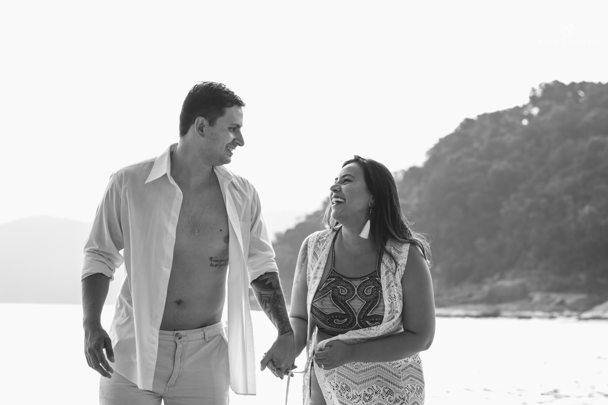 ensaio pre casamento na praia de ubatuba em sao paulo casal de blusa branca com fotos nas pedras e na agua cristalina