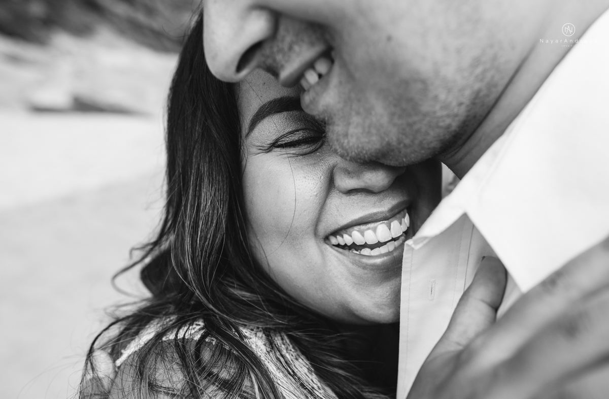 ensaio pre casamento na praia de ubatuba em sao paulo casal de blusa branca com fotos nas pedras e na agua cristalina