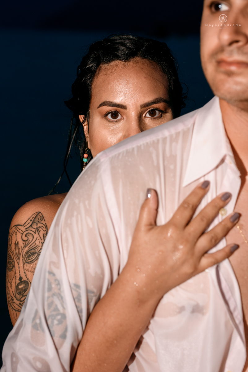 ensaio pre casamento na praia de ubatuba em sao paulo casal de blusa branca com fotos nas pedras e na agua cristalina
