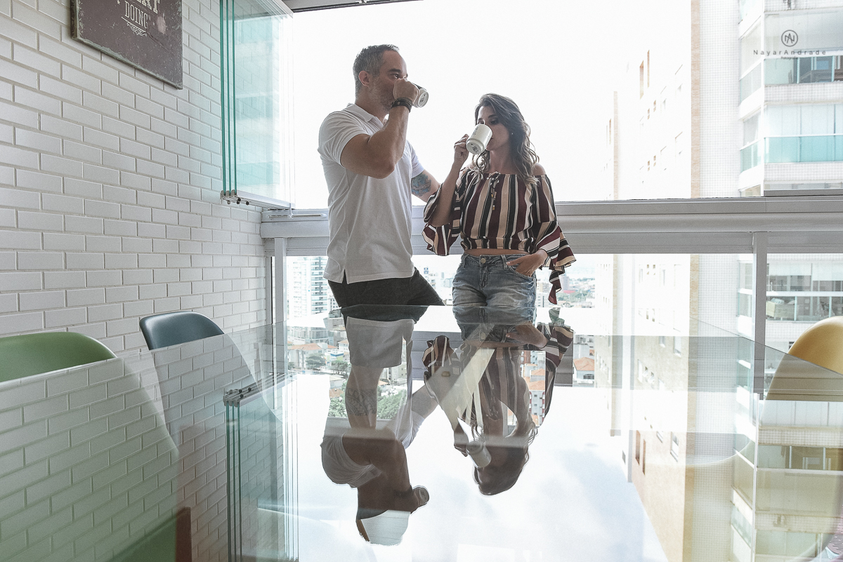 ensaio casal pre wedding feito na casa do casal com cafe, pipoca, cachorrinho e depois fotos feitas na praia com por do sol e a o anoitecer