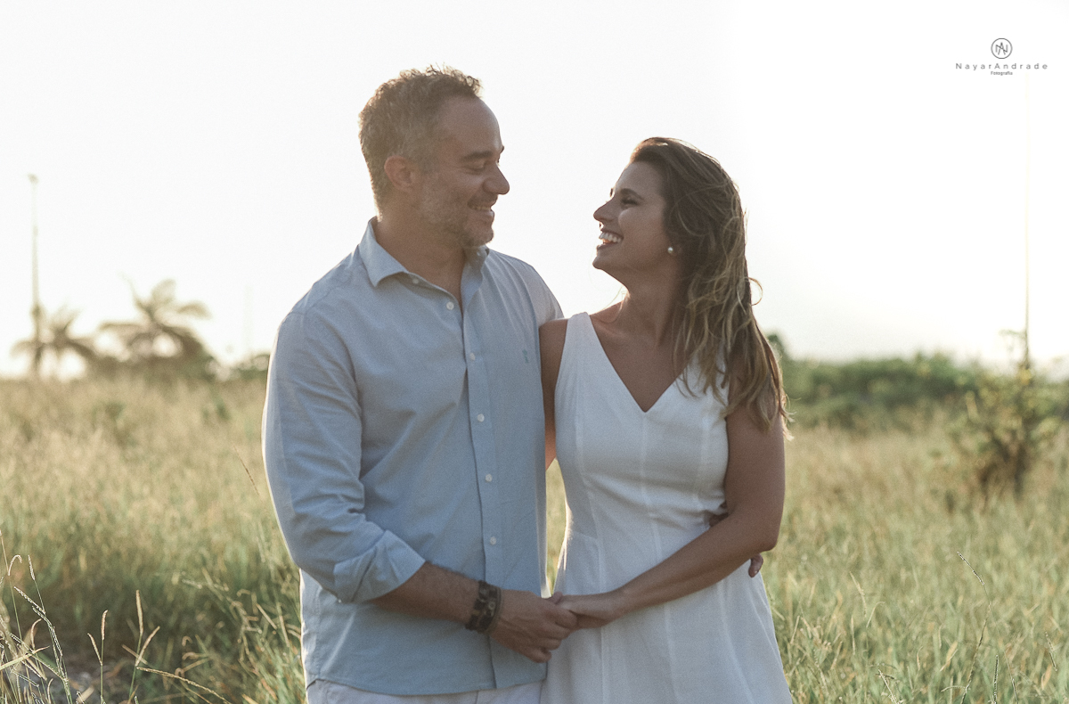 ensaio feito no fim de tarde na praia com a golden hour lindos raios de sol e luz natural casal romantico e apaixonado