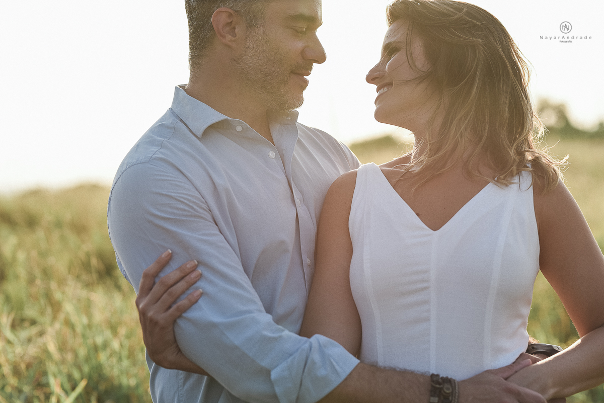 ensaio feito no fim de tarde na praia com a golden hour lindos raios de sol e luz natural casal romantico e apaixonado