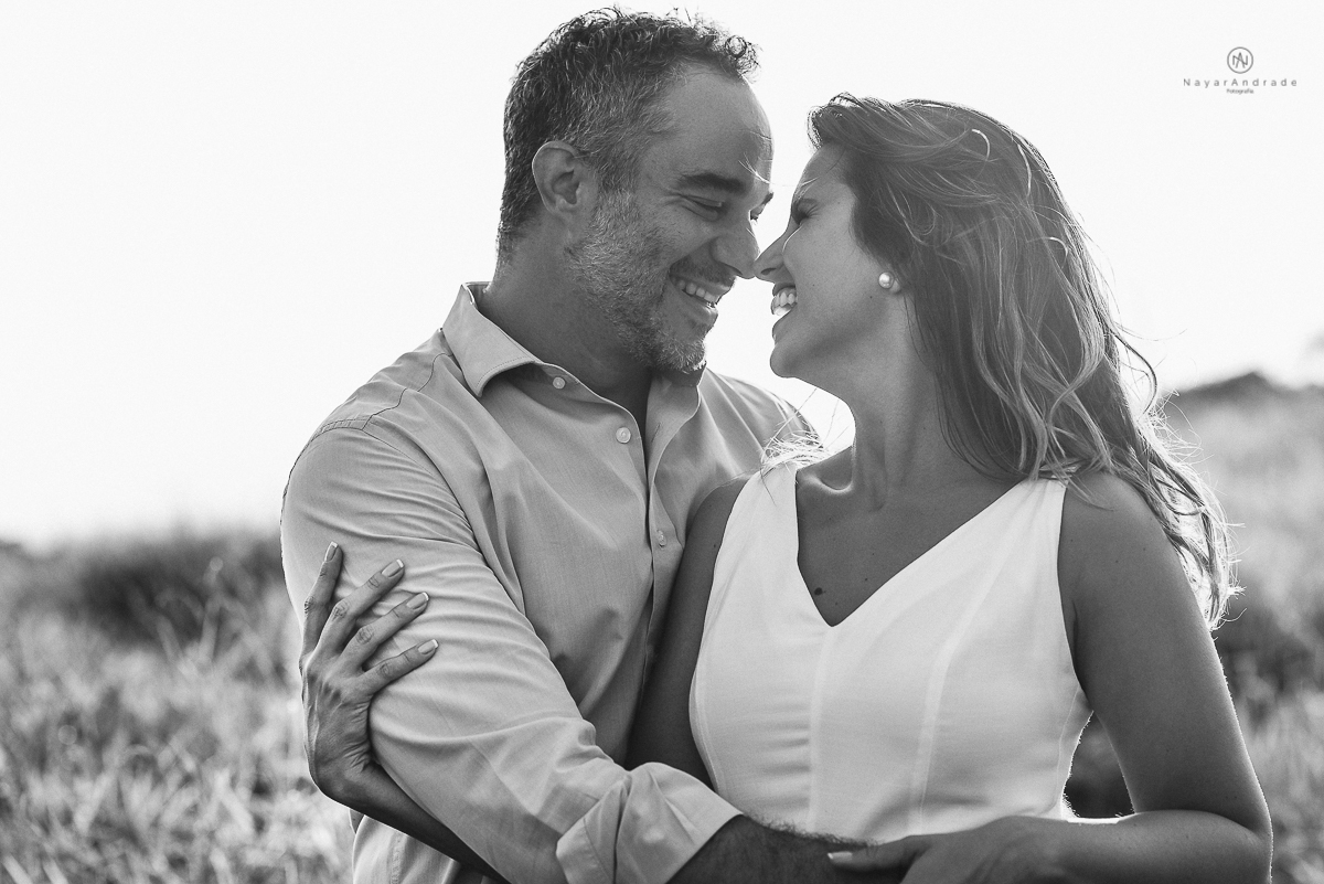 ensaio feito no fim de tarde na praia com a golden hour lindos raios de sol e luz natural casal romantico e apaixonado