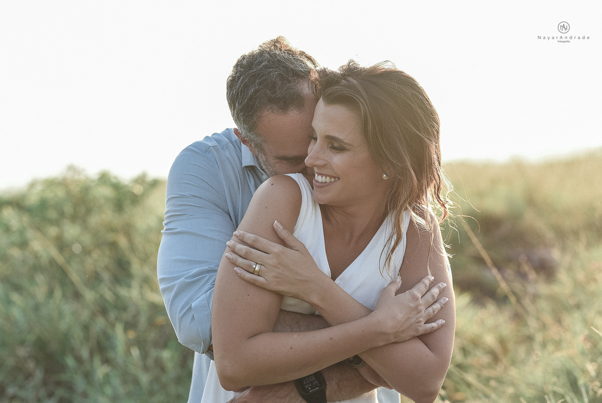 ensaio feito no fim de tarde na praia com a golden hour lindos raios de sol e luz natural casal romantico e apaixonado